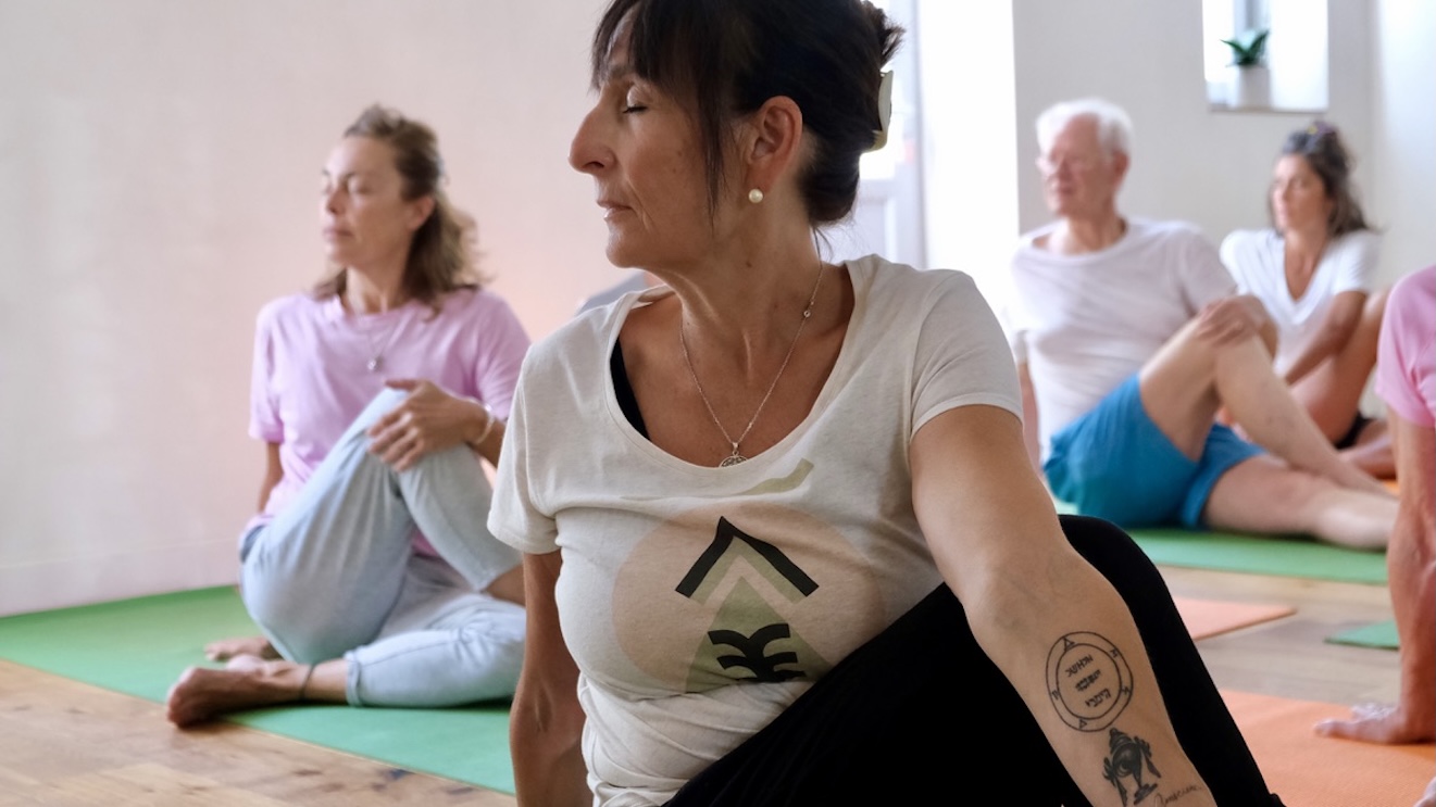 Yoga pour l'énergie Elèves dans la torsion assise dans un cours de yoga à Biarritz